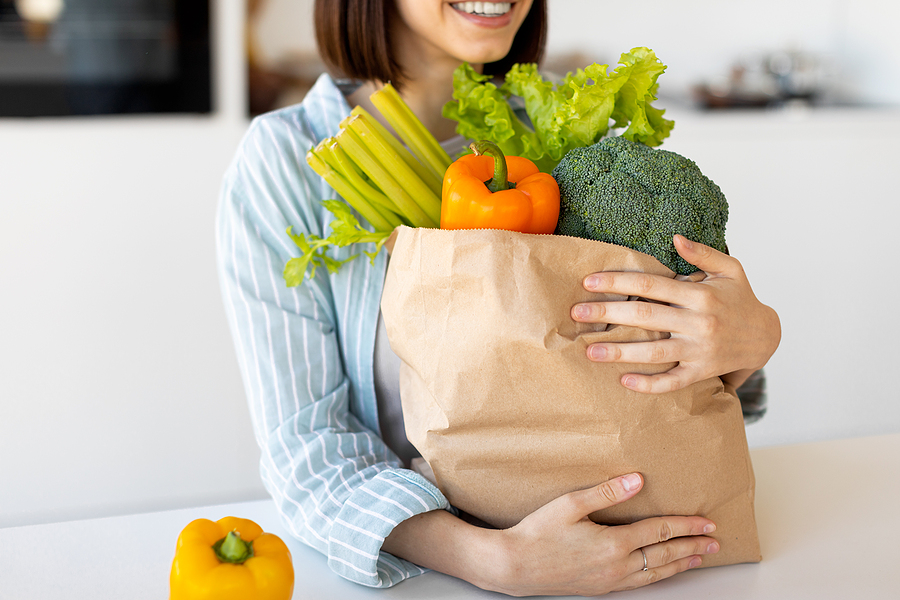 woman holding bag of vegetables