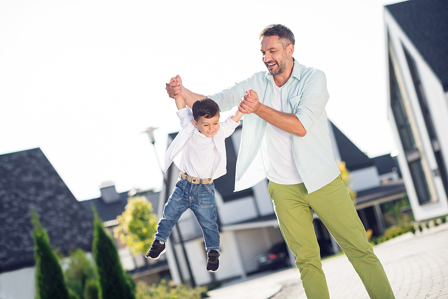 dad swinging young son with his arms