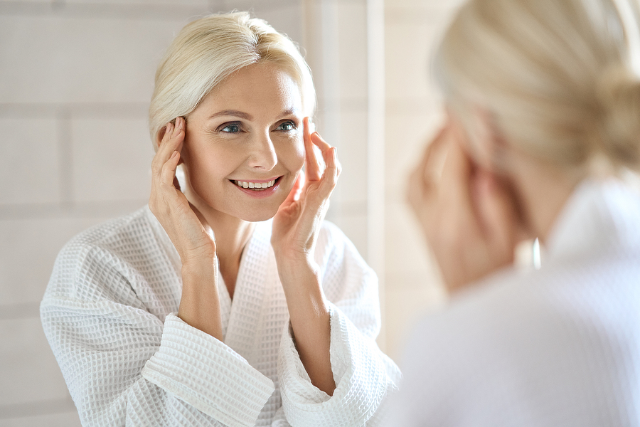 beautiful blonde woman looking in mirror 