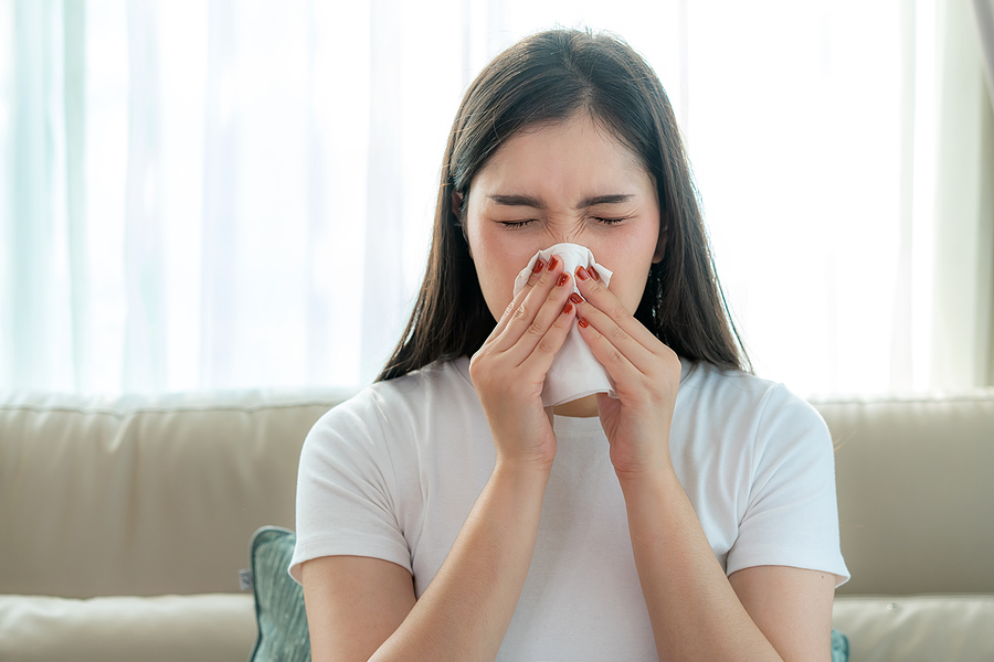 dark hair woman sneezing