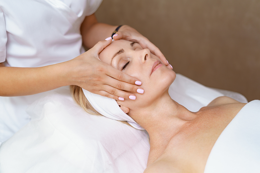 blonde woman getting facial treatment at spa