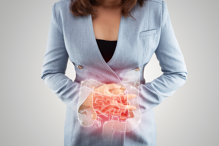 woman in blue suit holding stomach in pain