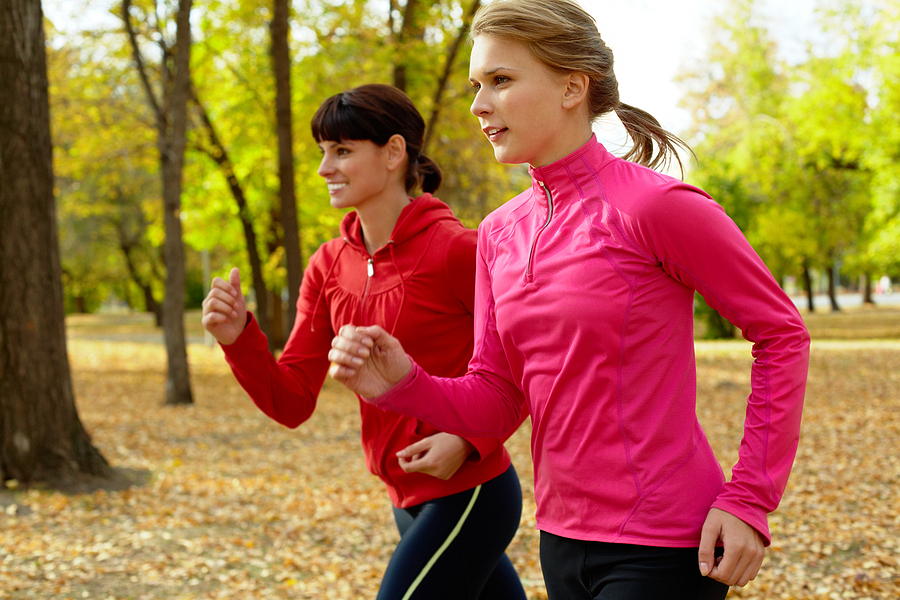 two women running outside in park