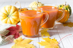 glasses of orange smoothie drink with pumpkins
