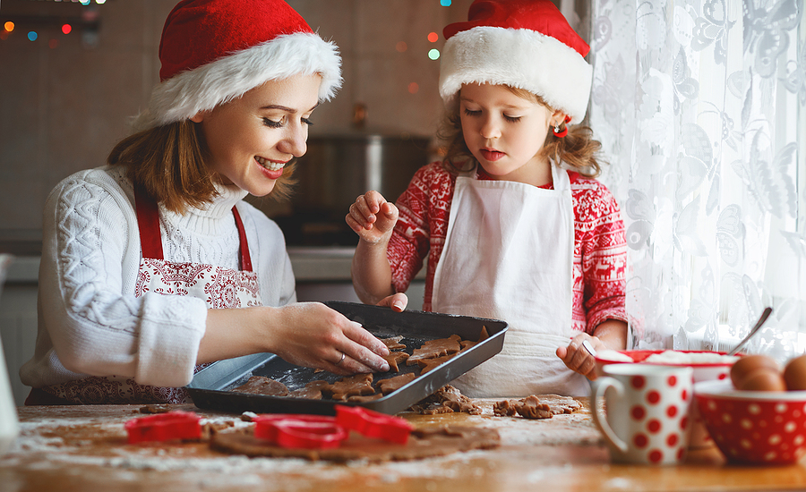 mother and daughter baking Christmas cookies in kitchen