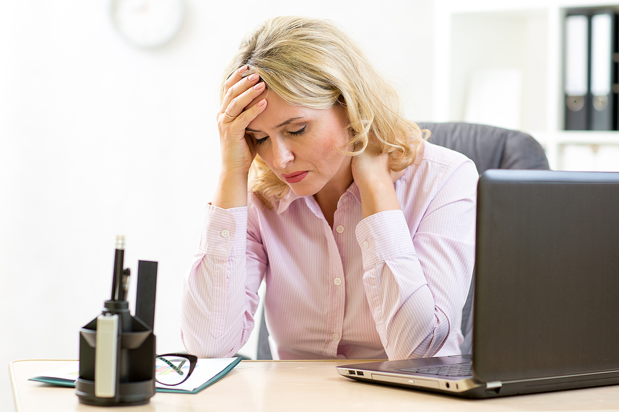 blonde mid age woman not feeling well at work