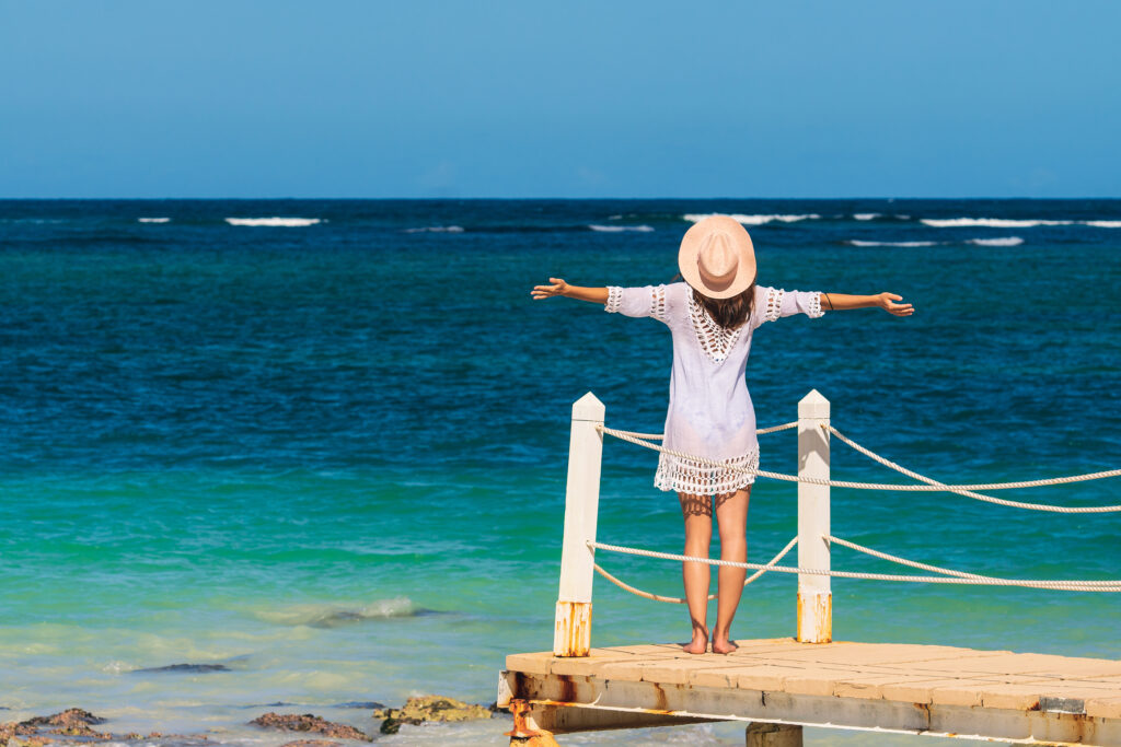 Happy woman on a pier overlooking the ocean.