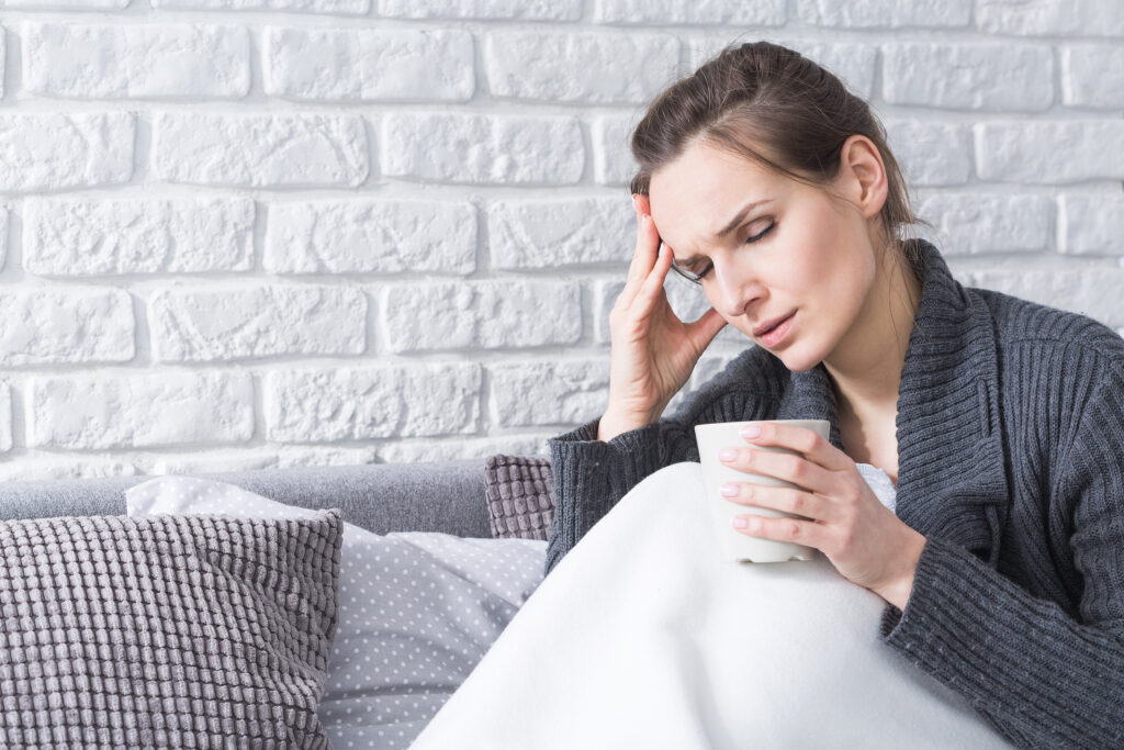 Young woman with headache trying to treat migraine naturally
